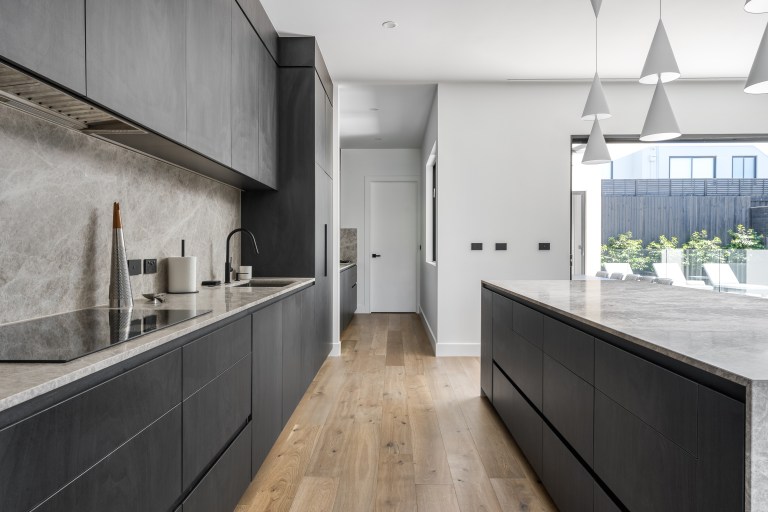 Dark contemporary kitchen with stone finishes in the New Alia Home build in Balwyn