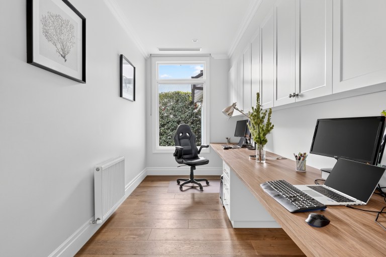Home office with a long timber desk and built-in joinery in Surrey Hills