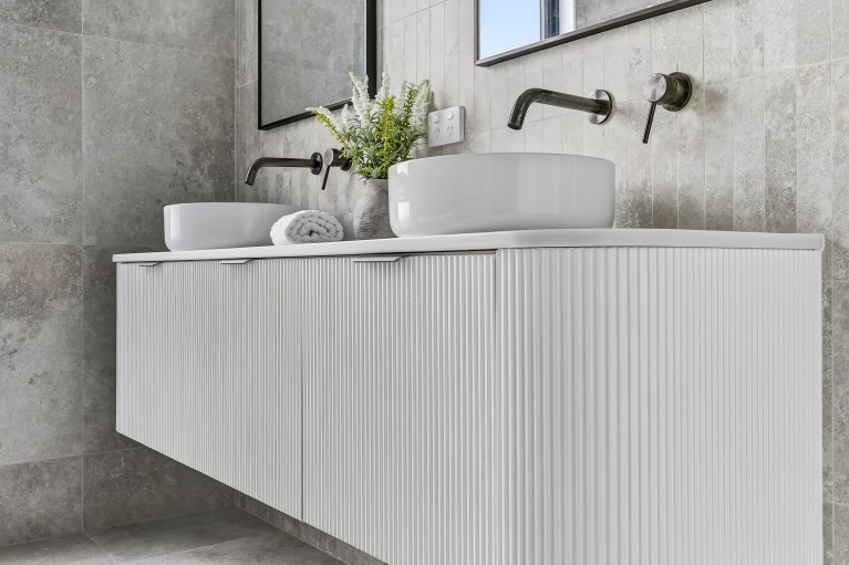 Close view of the fluted double vanity and wall-mounted tapware in the New Alia Home build